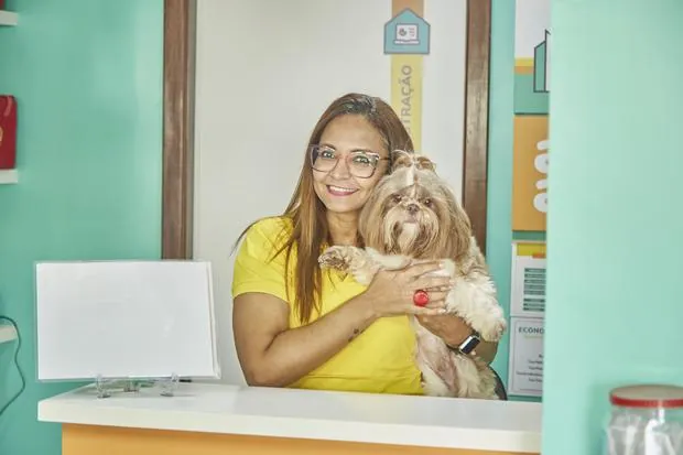 Recepcionista da Creche com um cão no colo